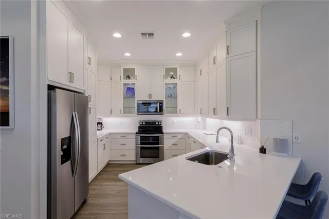 a kitchen with refrigerator a sink and cabinets