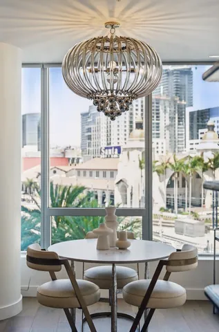 a room with furniture a chandelier and large windows
