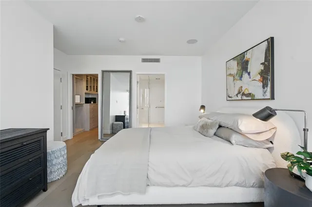 a bedroom with a bed and a painting on the wall