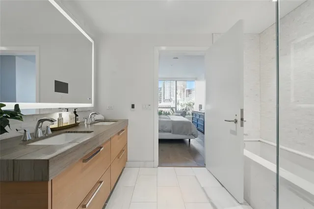 a en suite bathroom with a granite countertop sink and a mirror