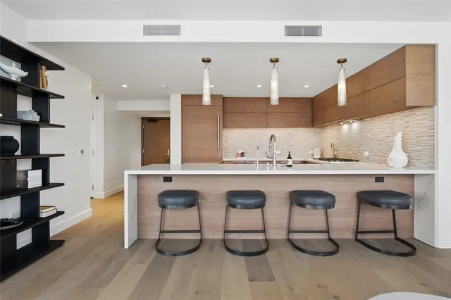 a large kitchen with granite countertop a oven a sink a dining table and chairs