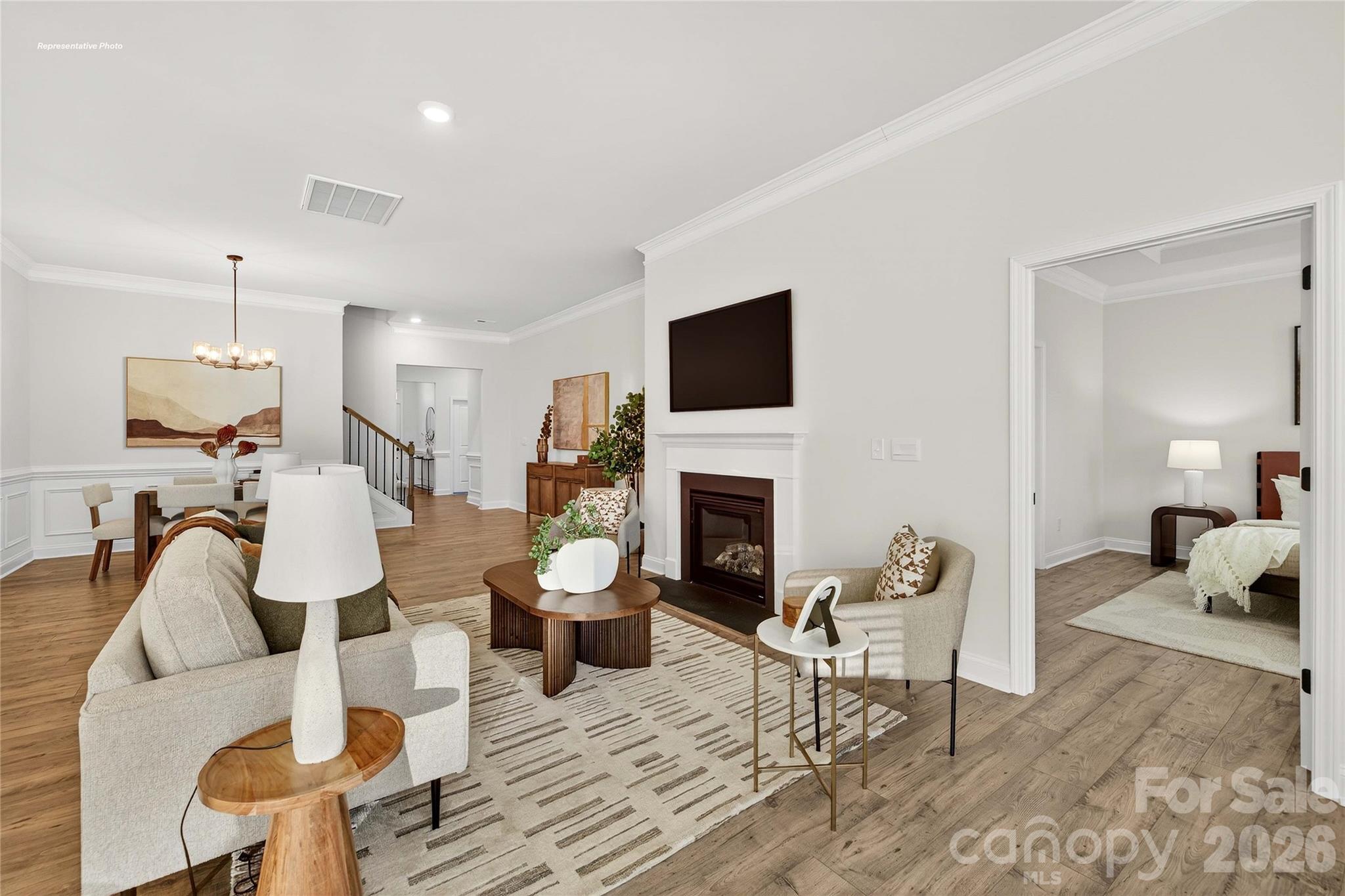 111 Rhuidean Court Troutman, NC 28166 - Photo 6 of 28 a living room with furniture a fireplace and a flat screen tv