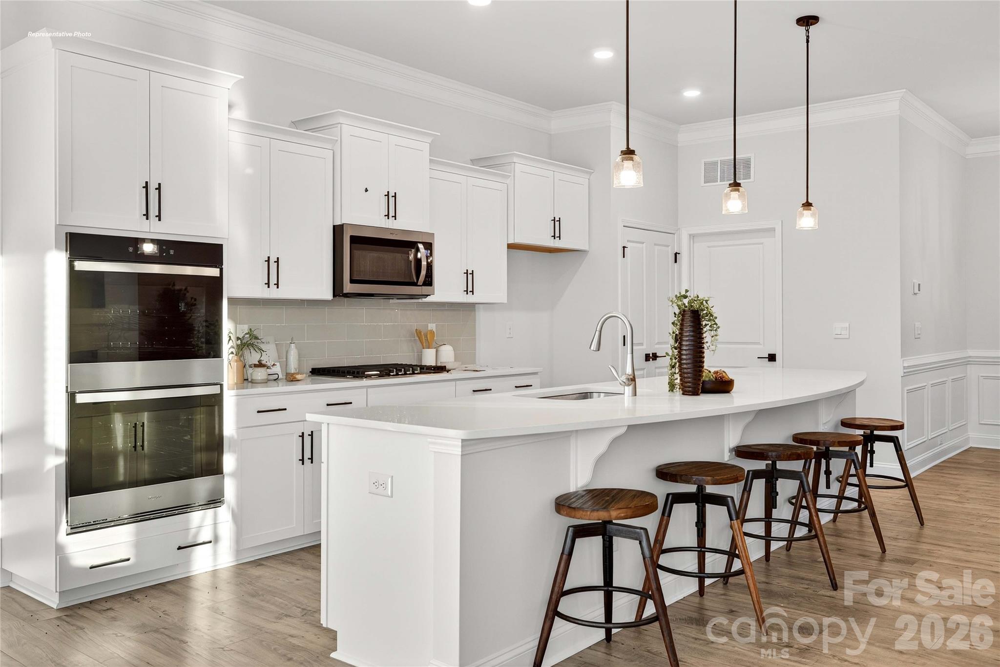 111 Rhuidean Court Troutman, NC 28166 - Photo 10 of 28 a kitchen with stainless steel appliances kitchen island a table chairs microwave and sink