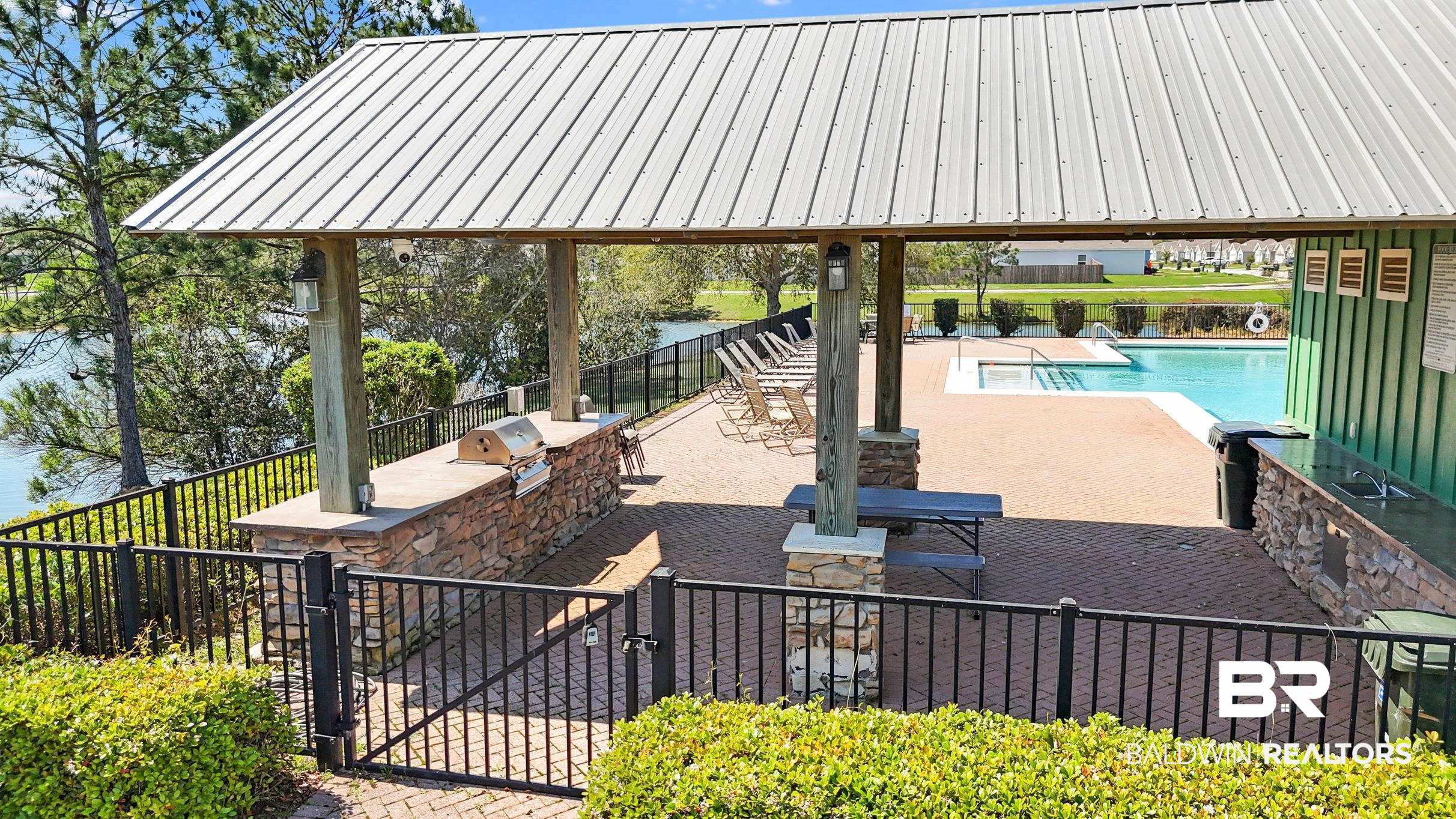 17449 Harding Drive Foley, AL 36535 - Photo 44 of 52 View of patio featuring a grill, a water view, area for grilling, and a community pool