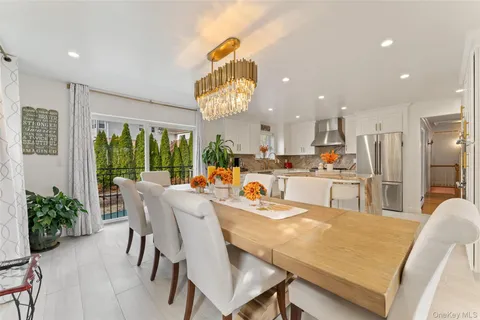 a dining room with stainless steel appliances kitchen island granite countertop a dining table chairs and granite counter tops