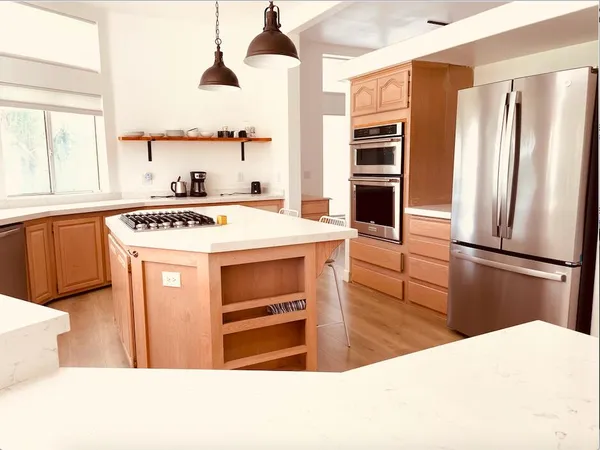 a kitchen with stainless steel appliances a stove a refrigerator and a sink