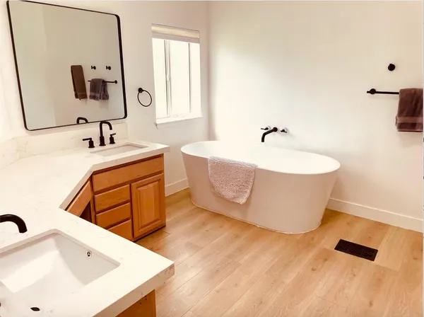 a bathroom with a tub sink and mirror