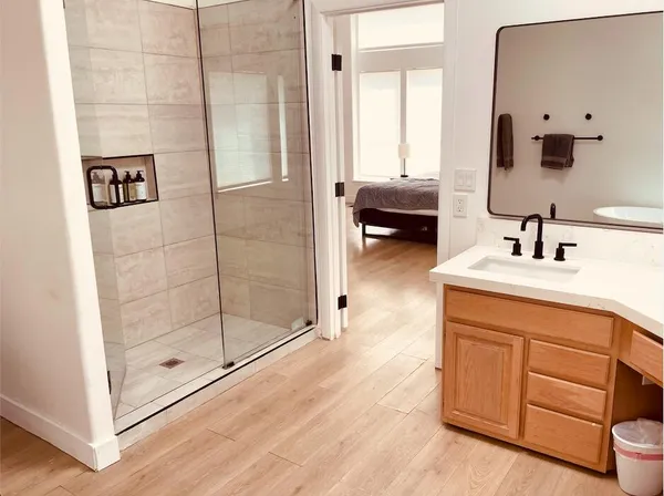 a en suite bathroom with a shower sink and mirror