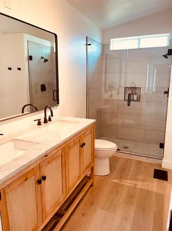 a bathroom with a double vanity sink toilet and shower