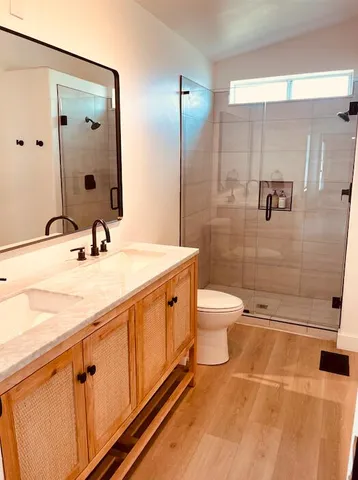 a bathroom with a double vanity sink toilet and shower