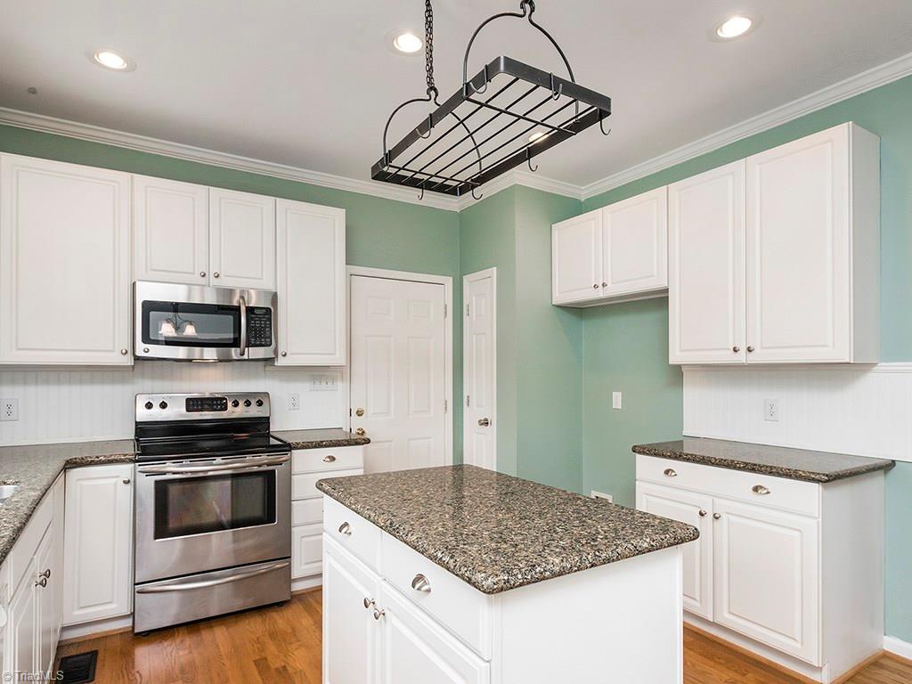 2806 Norwell Court Oak Ridge, NC 27310 - Photo 7 of 30 Large Island with Pan Rack above and Pantry next to Garage Access. Built-in microwave provides extra counter space. Tons of storage! 2 pantries. Large pantry not shown