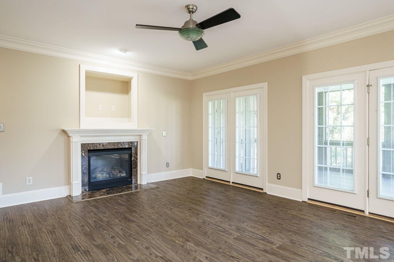 2000 Sageleaf Court Raleigh, NC 27603 - Photo 21 of 33 an empty room with wooden floor fireplace and windows