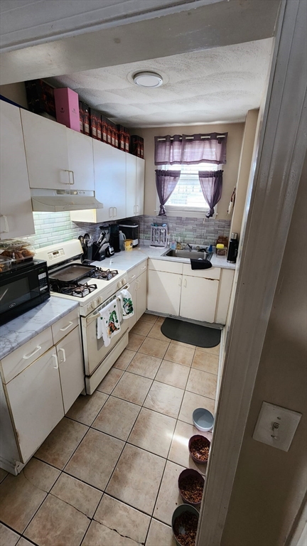 14 Valley Avenue Lynn, MA 01902 - Photo 7 of 16 a kitchen with stainless steel appliances granite countertop a sink and cabinets