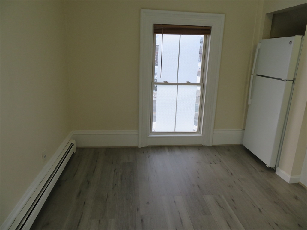 160 High Street, Unit 3 Wareham, MA 02571 - Photo 3 of 8 an empty room with wooden floor and window