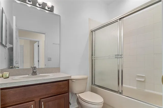 a bathroom with a sink toilet vanity and shower