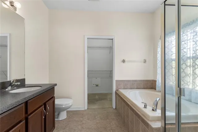 a bathroom with a granite countertop sink a toilet and shower