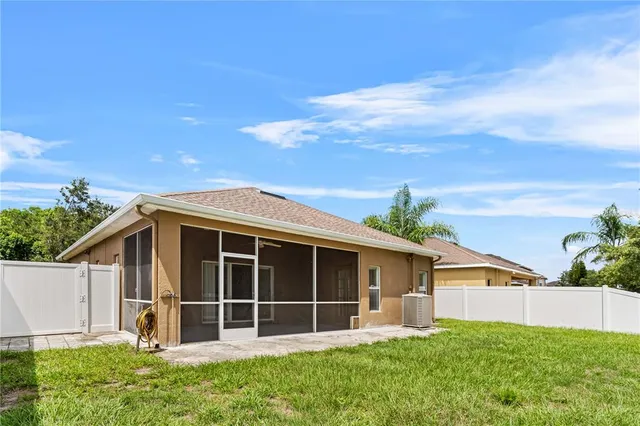 a view of a house with a yard and potted plants