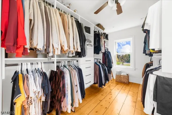 a view of walk in closet with clothes and shoes