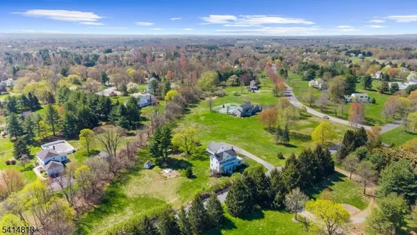 an aerial view of residential houses with outdoor space and trees
