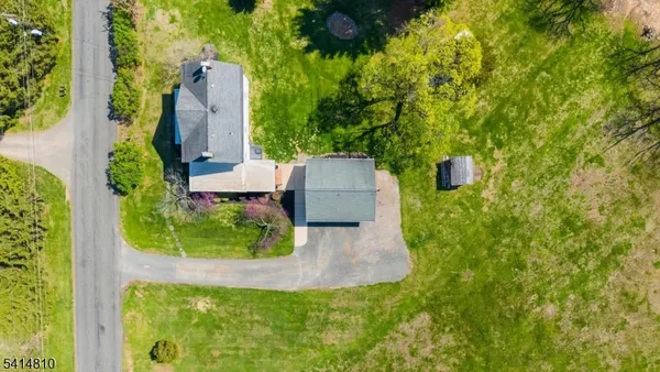 an aerial view of a house with a yard and trees