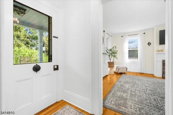 a view of a hallway to a livingroom with furniture and a window