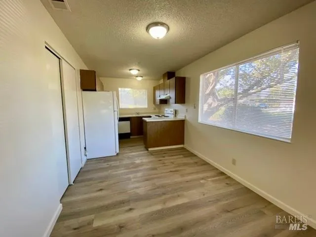 a view of kitchen with stainless steel appliances cabinets and a refrigerator