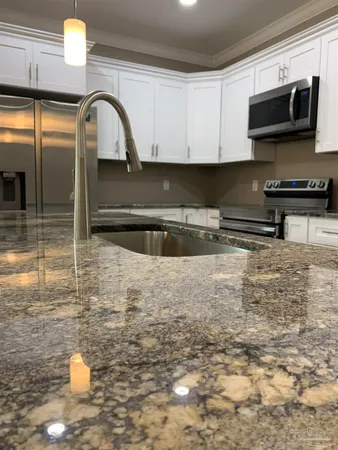 a large kitchen with stainless steel appliances kitchen island a large counter top and a stove top oven