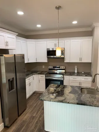 a view of a kitchen with a sink and wooden floor