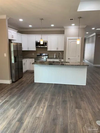 a kitchen with granite countertop a sink and cabinets