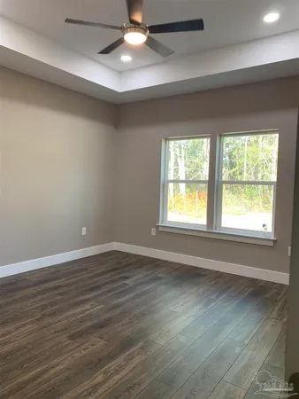 an empty room with wooden floor and a sink