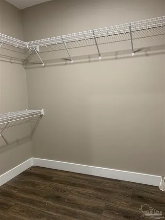 a view of an empty room with wooden floor and closet