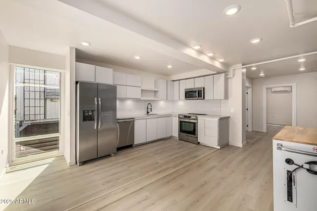 a kitchen with stainless steel appliances a refrigerator and a stove top oven