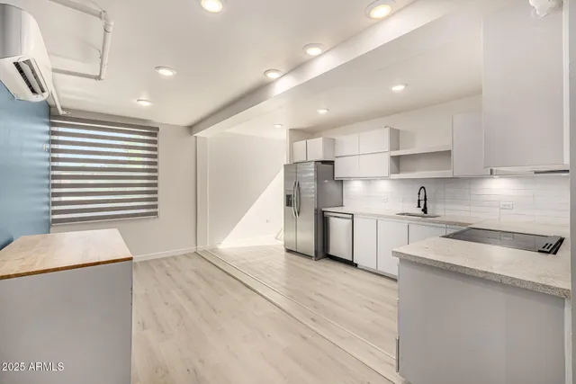 a kitchen with stainless steel appliances granite countertop a sink a stove and a refrigerator