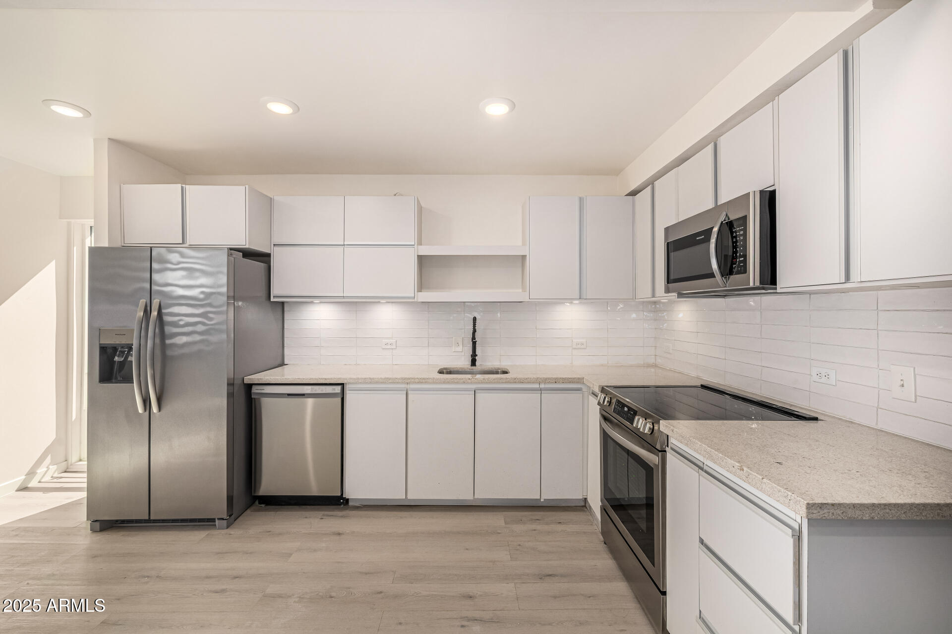 5306 East Polk Street, Unit 305 Phoenix, AZ 85008 - Photo 5 of 13 a kitchen with stainless steel appliances a refrigerator sink and microwave