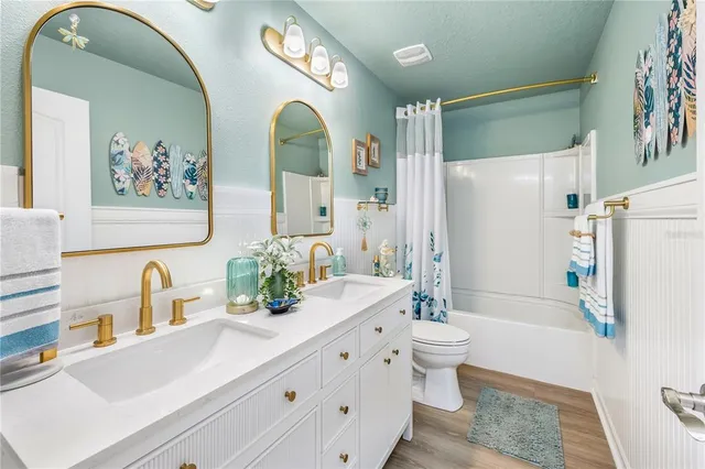 a large white kitchen with stainless steel appliances a stove a chimney a sink and a counter top space