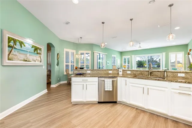 a dining table chairs wooden floor and kitchen view