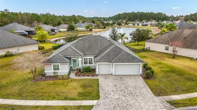 an aerial view of a house with outdoor space and swimming pool