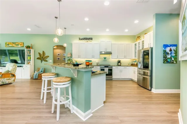 a dining room with furniture a chandelier and wooden floor
