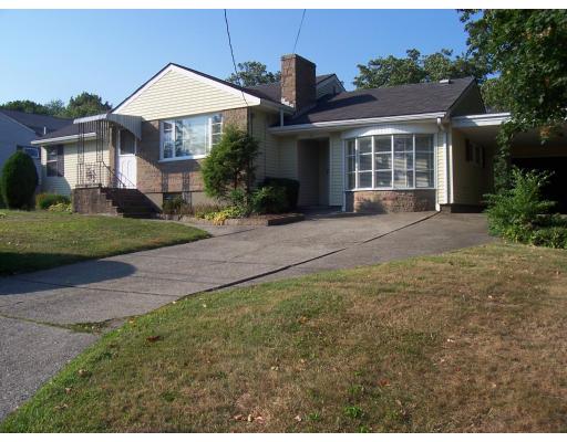 a front view of a house with a yard and potted plants