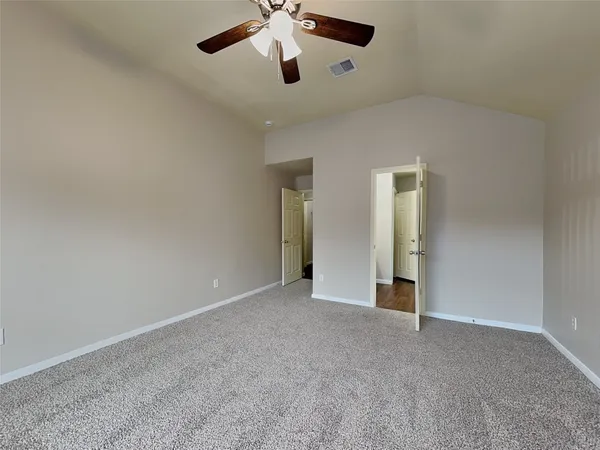 an empty room with chandelier fan