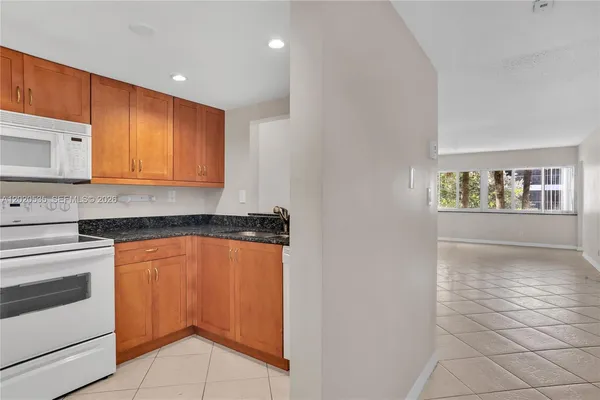 a kitchen with stainless steel appliances granite countertop a stove a microwave and a sink