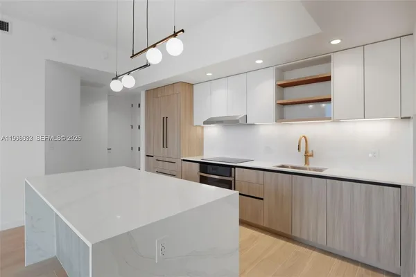 a kitchen with kitchen island a sink appliances and cabinets