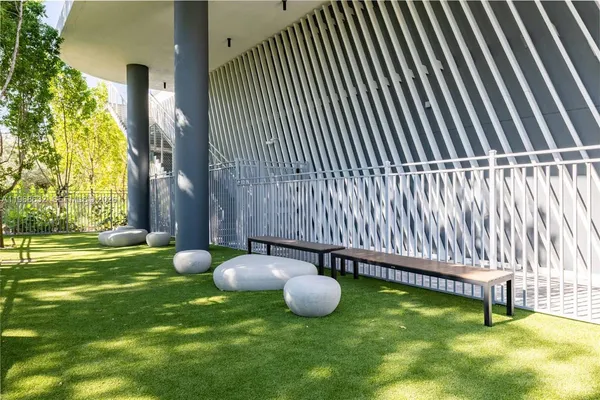 a view of a white house with a yard and sitting area