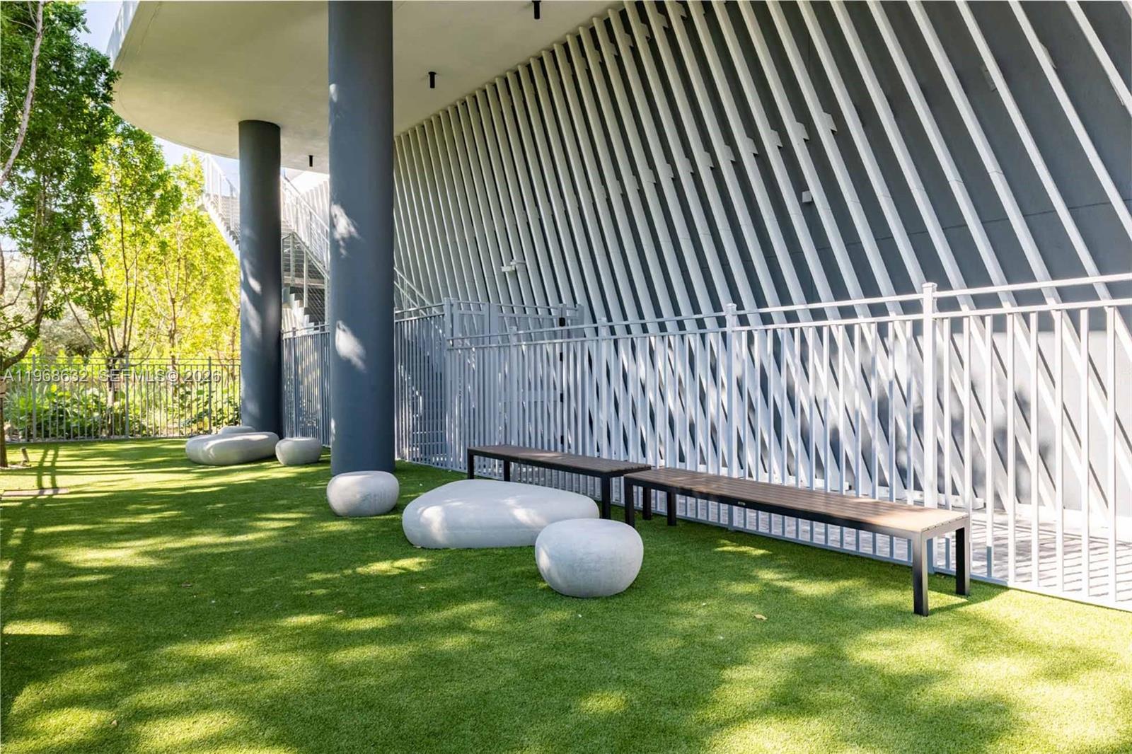 3900 Alton Road, Unit 208 Miami Beach, FL 33140 - Photo 19 of 26 a backyard of a house with table and chairs