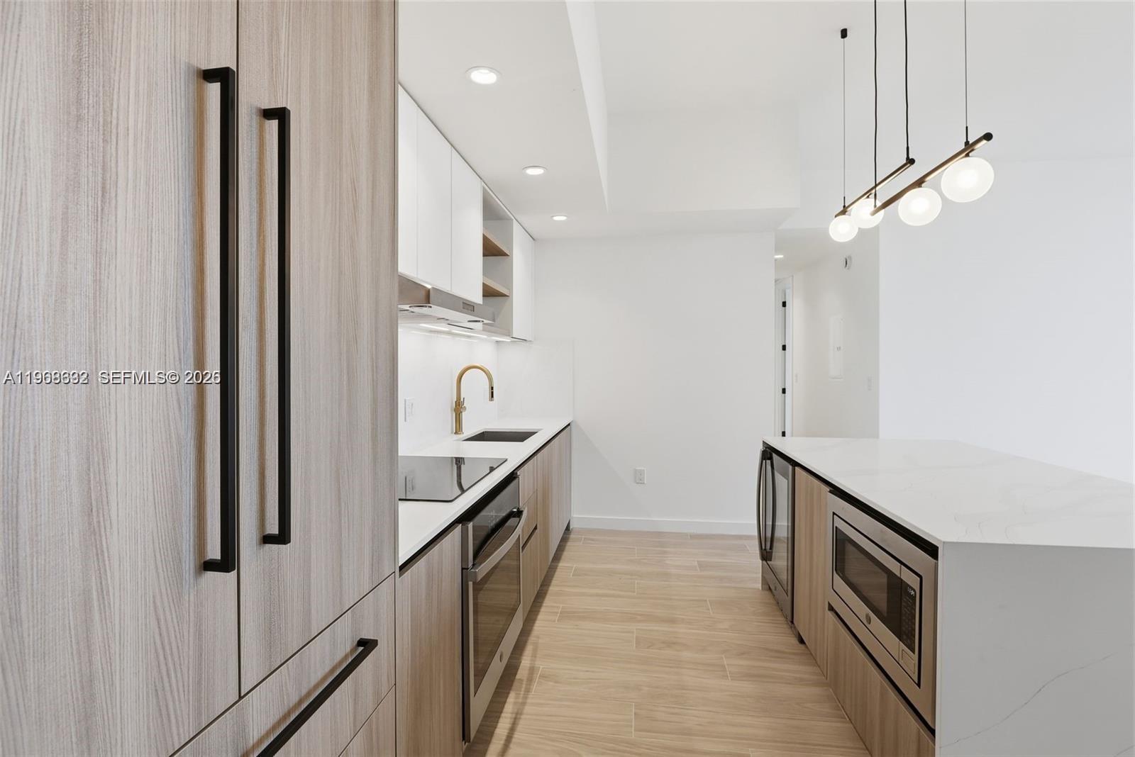3900 Alton Road, Unit 208 Miami Beach, FL 33140 - Photo 9 of 26 a kitchen with stainless steel appliances a refrigerator and a stove