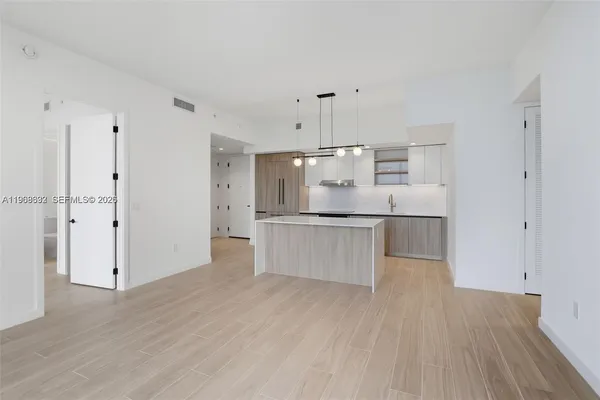 a large kitchen with a wooden floor and stainless steel appliances