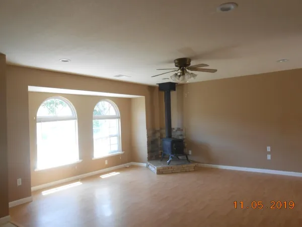 a view of empty room with a ceiling fan and window