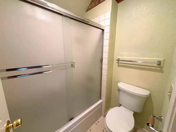 a white toilet sitting next to a shower