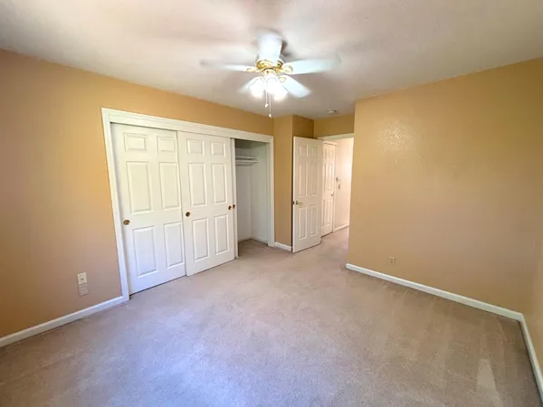 an empty room with a ceiling fan and a window
