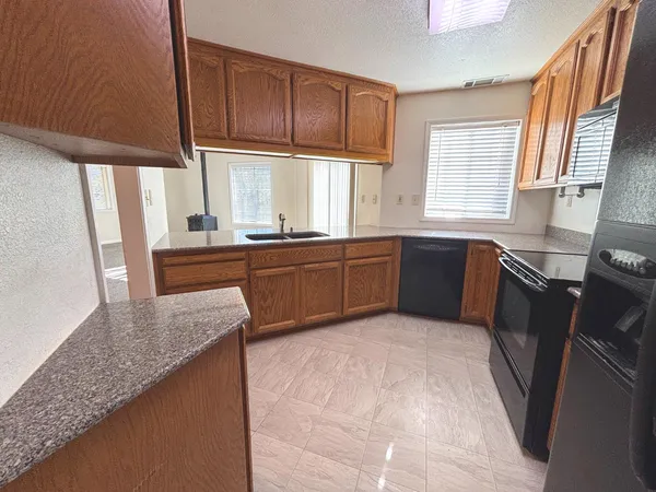 a kitchen with stainless steel appliances granite countertop wooden cabinets a sink and a stove
